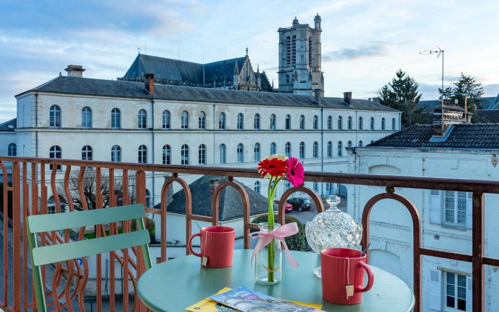 特鲁瓦Aux Deux Clochers de Troyes的阳台上的花瓶桌子