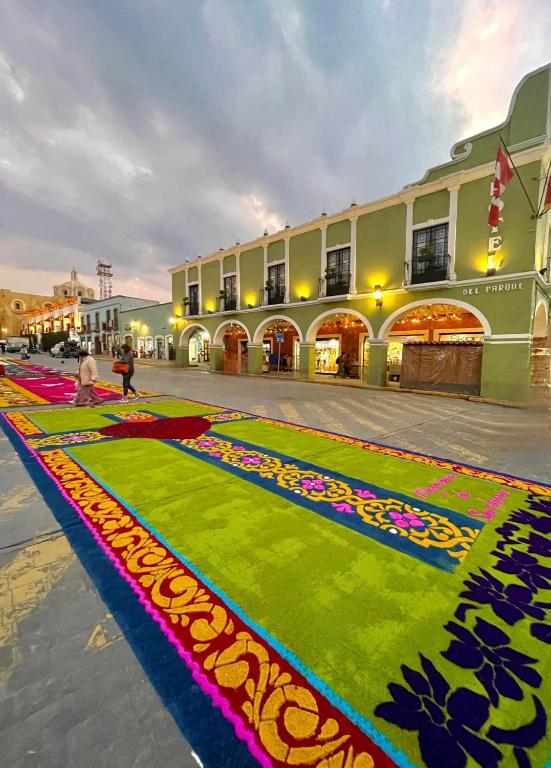 瓦曼特拉Hotel Del Parque的建筑前有色彩缤纷地毯的街道