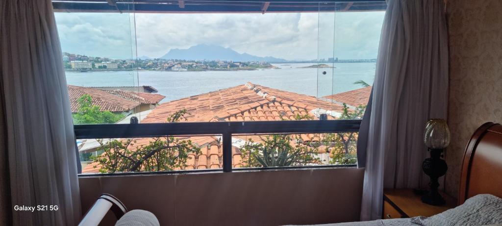 维拉维尔哈Pousada do Farol Bar e Restaurante的一间卧室设有大窗户,享有水景