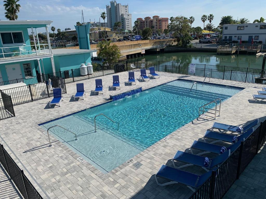 圣徒皮特海滩Sea Jay Motel and Marina的一个带蓝色躺椅的游泳池和一个游泳池