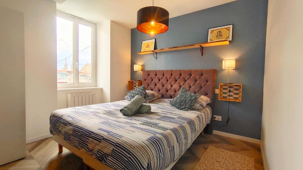尼奥尔Votre Escale - Magellan Cinéma的一间卧室配有一张蓝色墙壁的床