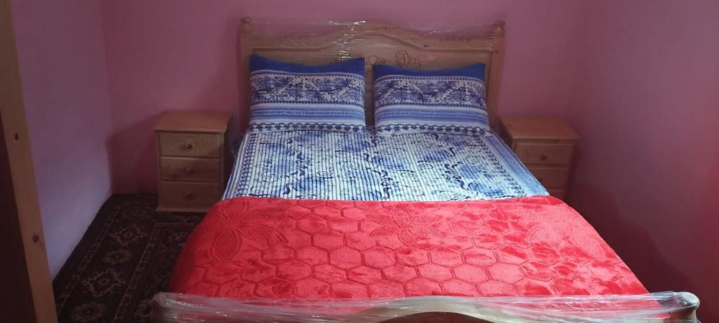 KetamaKetama كتامة的红色和蓝色的被子的房间里一张床位