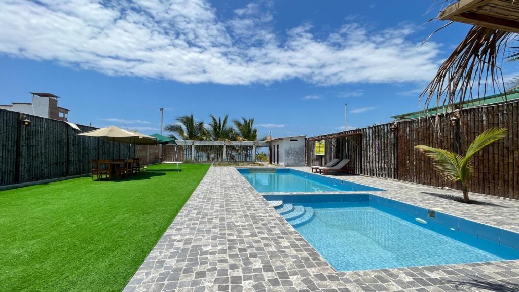 索里托斯Hospedaje & Casa Playa AURORA的后院设有游泳池和绿草