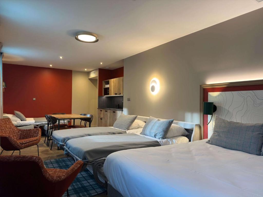圣让德莫里耶讷Best Western Hotel Coeur de Maurienne的酒店客房设有三张床和一张桌子