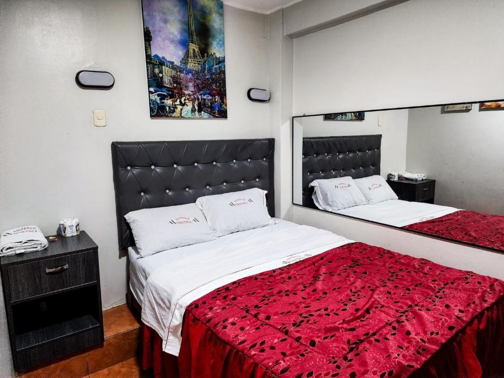 利马Hostal Paris的一间卧室配有两张带红毯的床