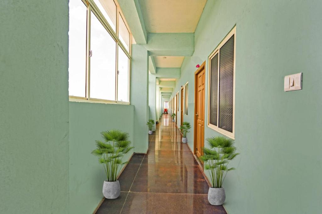 钦奈OYO Flagship 92943 Guna Residency的楼内带有盆栽的走廊
