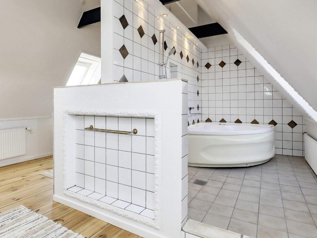 斯文堡20 person holiday home in Svendborg的白色的浴室设有浴缸和楼梯。