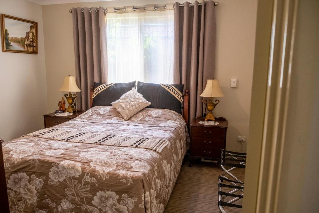 珀斯阿斯科特天鹅住宿加早餐旅馆的一间卧室配有一张床和两个带灯的床头柜