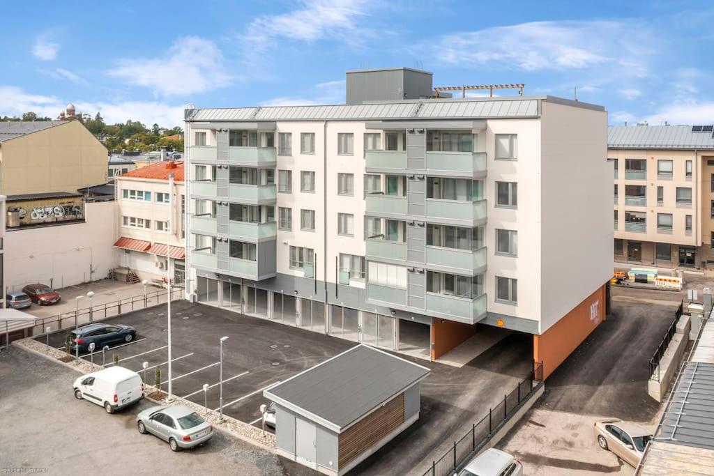 拉彭兰塔Upea yksiö ydinkeskustasta.的停车场内有车辆停放的公寓大楼