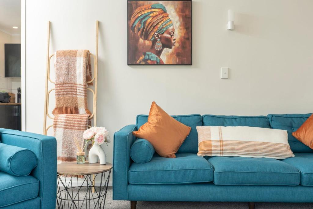 旺阿雷Riverside Retreat的客厅里一张蓝色的沙发,墙上挂着一幅画