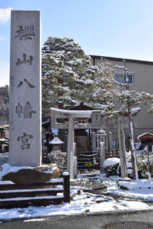 高山Karin House的建筑物前雪中的标志