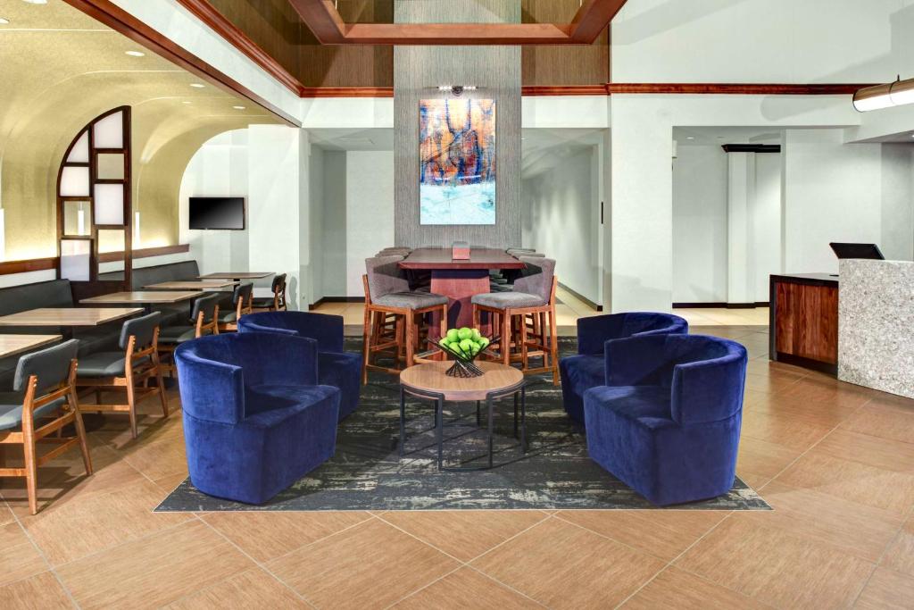 诺克罗斯Hyatt Place Atlanta / Norcross / Peachtree的大堂设有蓝色椅子和桌子,酒吧