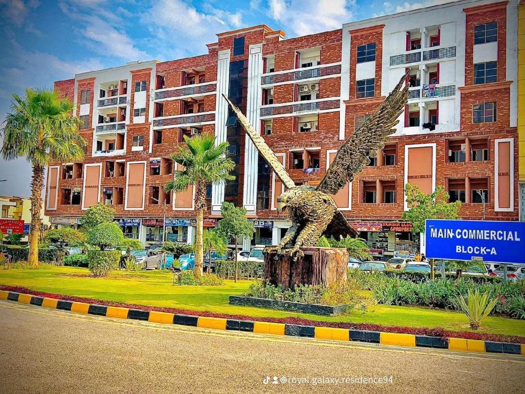 伊斯兰堡Royal Galaxy Residence & Hotel Apartments - Near to Islamabad International Airport & Motorway的鸟像在建筑物前
