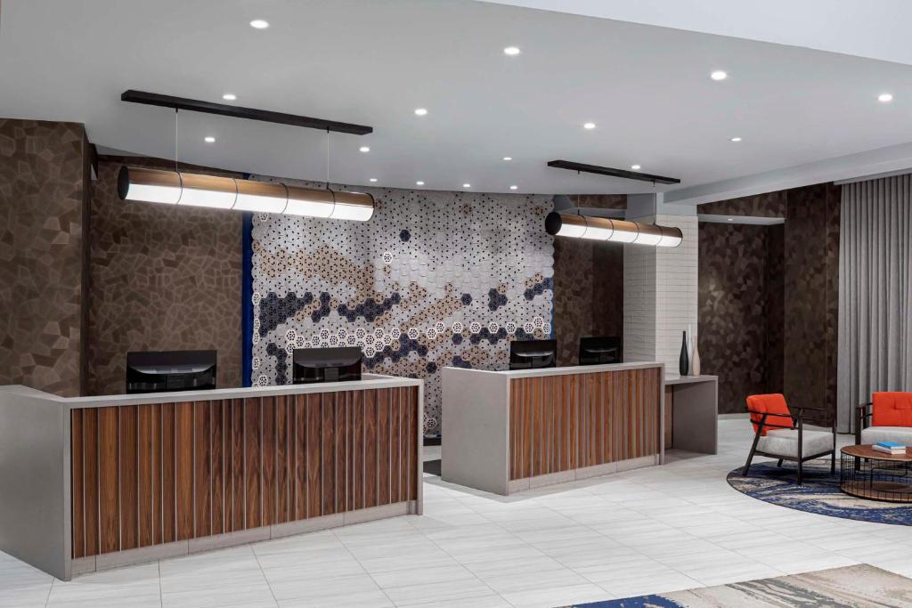 纽约Hyatt Place New York City - Times Square的一个带前台和椅子的办公大厅