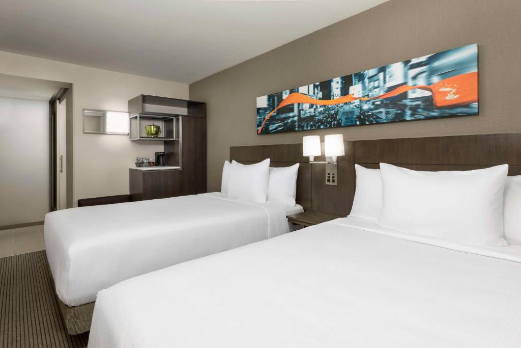 纽约Hyatt Place New York City - Times Square的酒店房间里有两张床，铺着白色床单