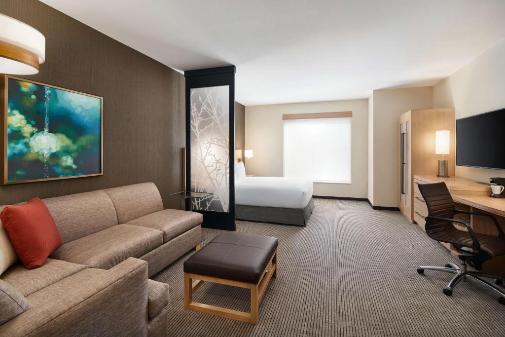 墨尔本Hyatt Place Melbourne - Palm Bay - I-95的酒店客房设有一张沙发和一张床
