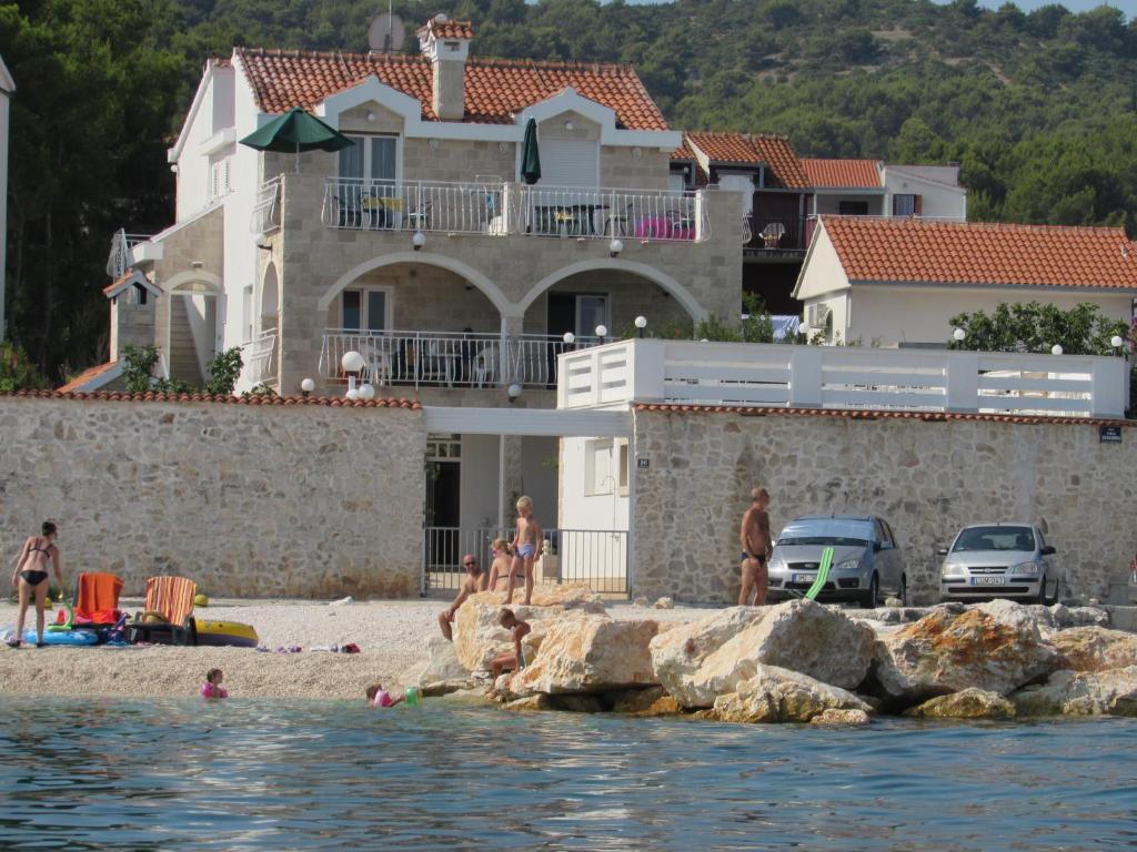 斯拉汀Bonacic Palace的一群人在房子前面的海滩上