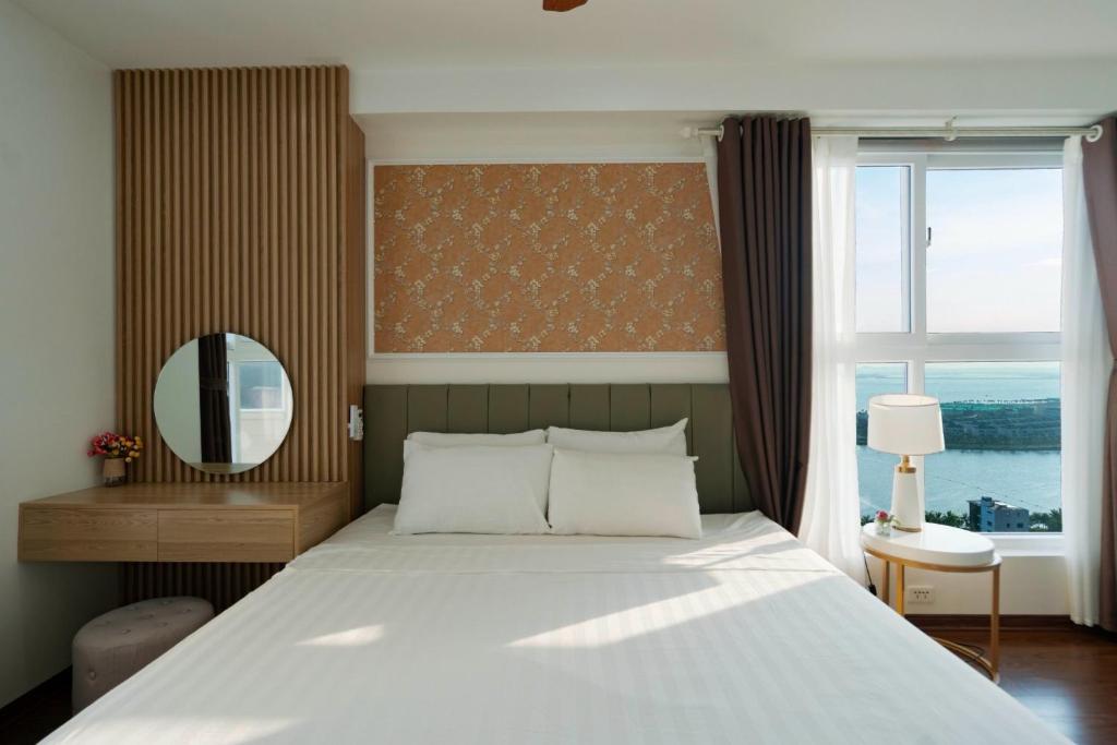 下龙湾Three-bedroom house with sea view的一间卧室配有一张床、镜子和窗户