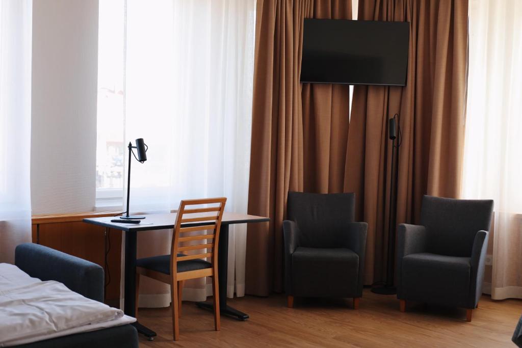 图尔库Hesehotelli Turku Linja-autoasema的客房设有书桌、两把椅子和一张床