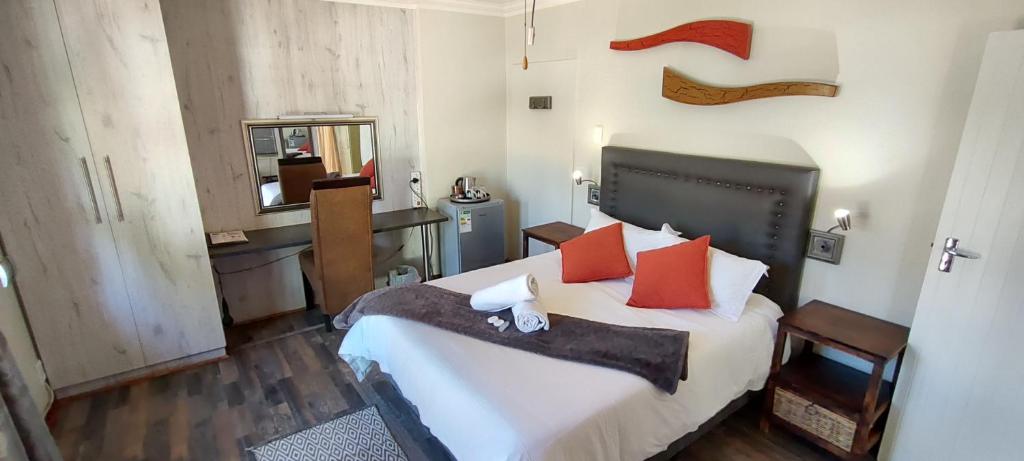 布隆方丹Premiere Guesthouse的一间卧室配有一张带红色枕头的大床