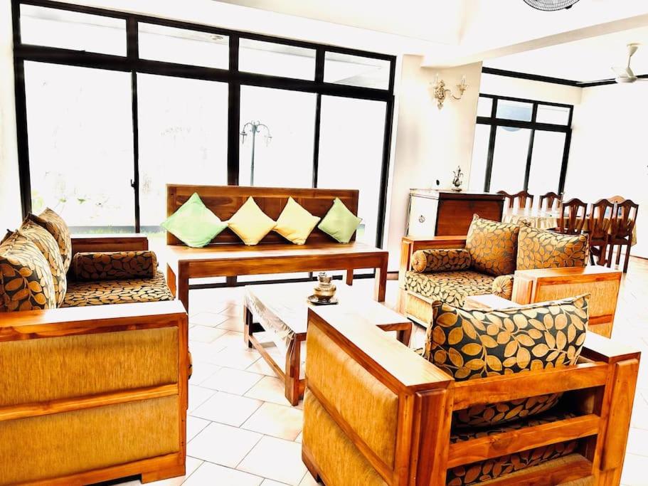 科伦坡VILLA COLOMBO7 5BR HOLIDAY HOME UP to 10 Guests的客厅配有木制家具和大窗户