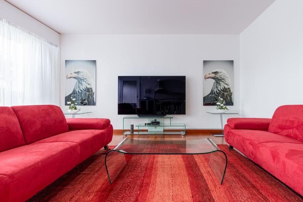 日内瓦Perle rare nations的客厅配有红色沙发和平面电视