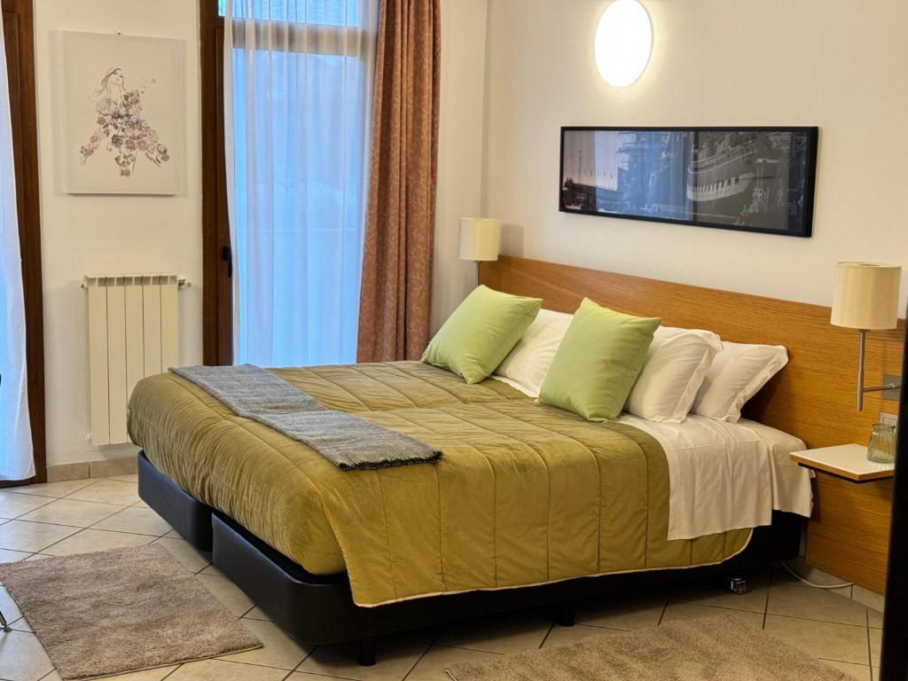索马伦巴多Residence Malpensa的一间卧室配有一张带绿色枕头的大床