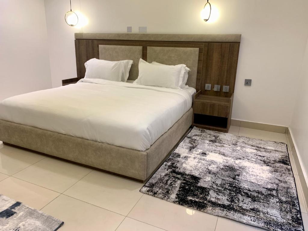 MaiduguriPolo Grand Hotel的一间卧室配有一张大床和地毯。