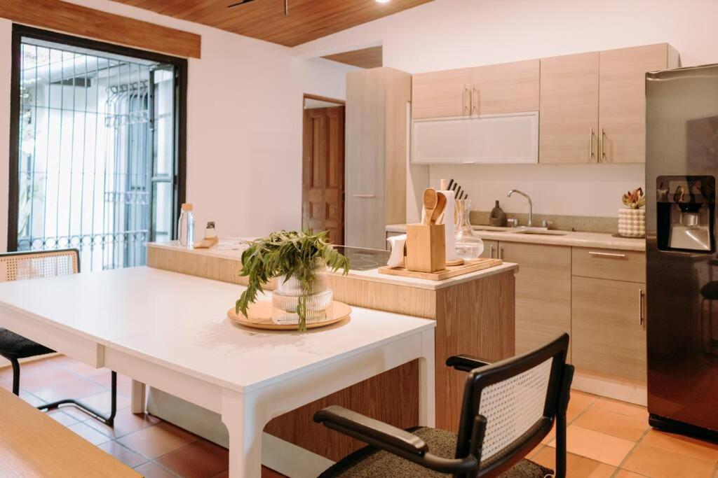 圣萨尔瓦多RN Villa - San Benito的厨房配有白色的桌椅和冰箱。