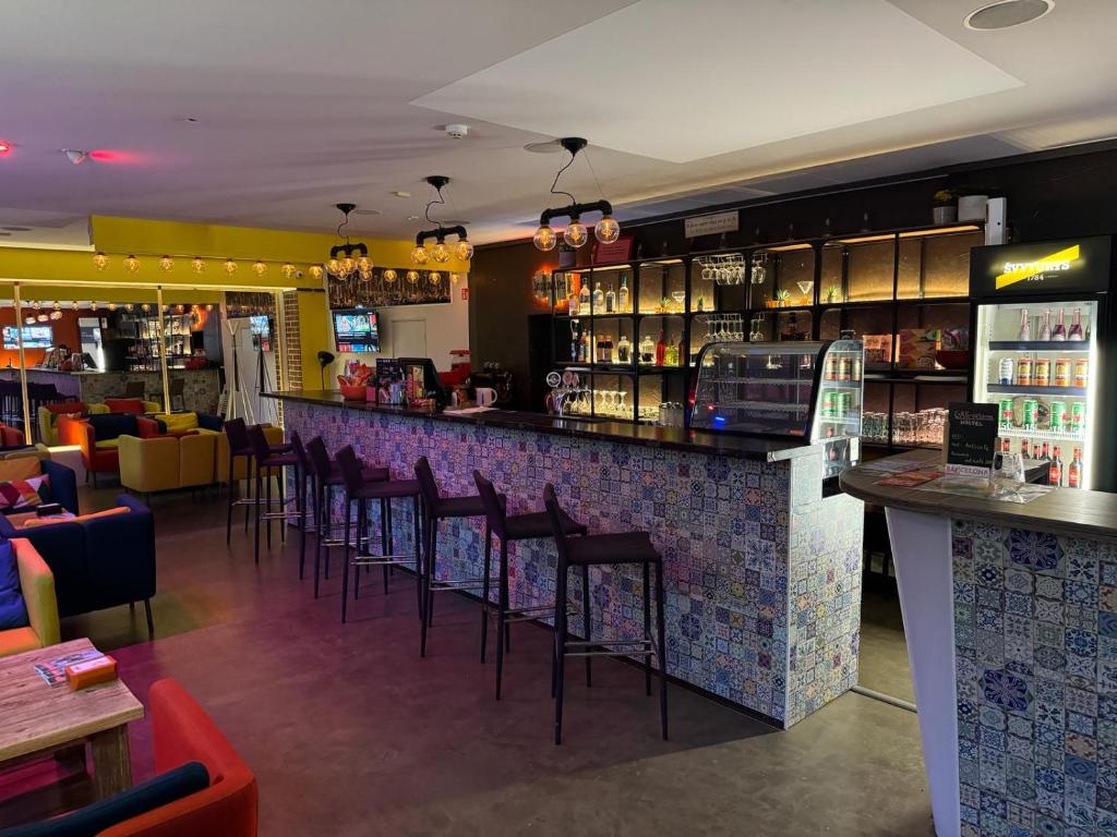 维尔纽斯Bar-celona的餐厅设有带凳子的酒吧