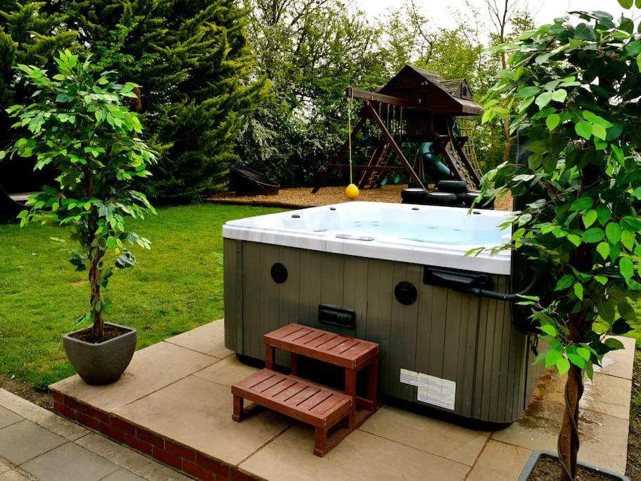 Great SampfordDeluxe 1 Bed Flat Hot Tub Sky Tv的树旁带长凳的热水浴池