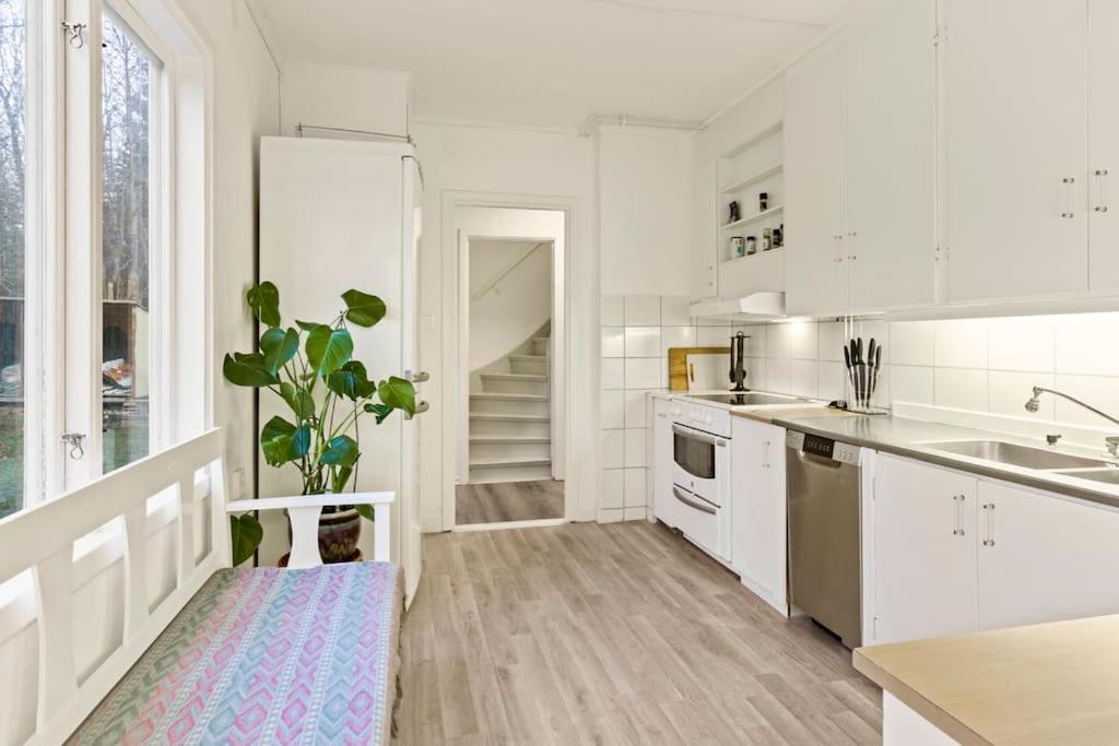奥克什贝里亚Comfy 4-bedroom barnhouse Ideal for Long Stays的厨房配有白色橱柜和盆栽植物