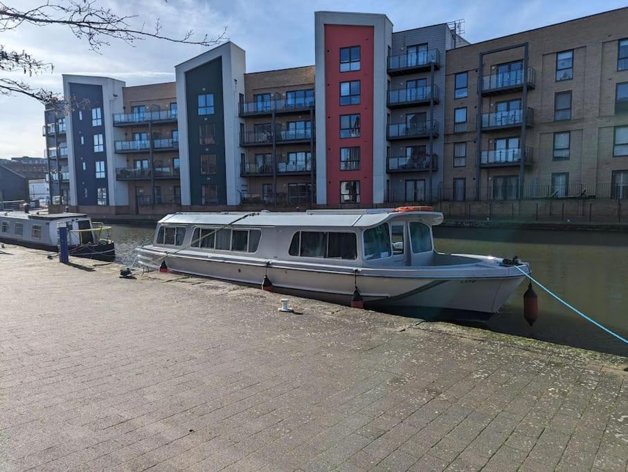 切姆Unique Boat in Chelmsford city的船停靠在建筑物旁边的水中