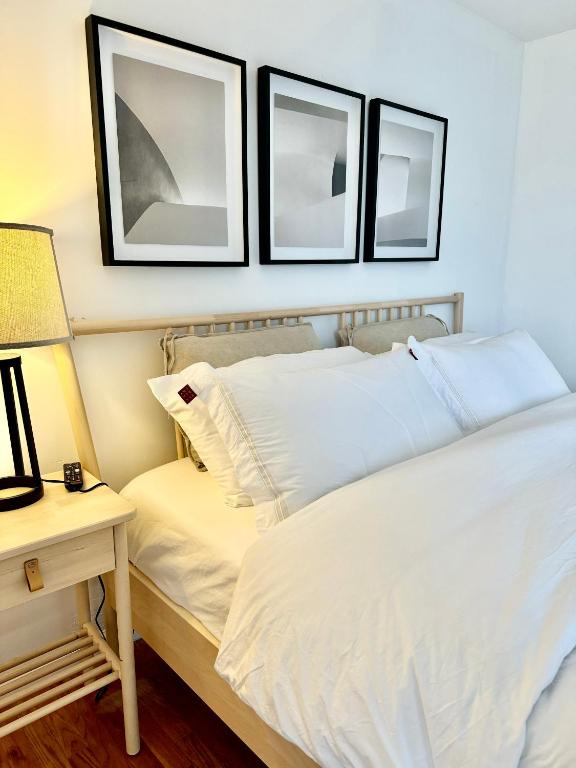 纽瓦克Stylish Evergreen Apartment By Newark Airport的一间卧室配有两张床和一张带台灯的桌子