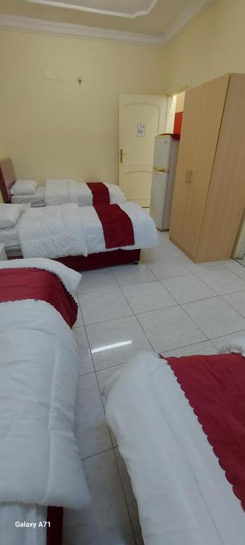 麦加ديار الحجاز 1的一间设有4张床及红色和白色枕头的客房