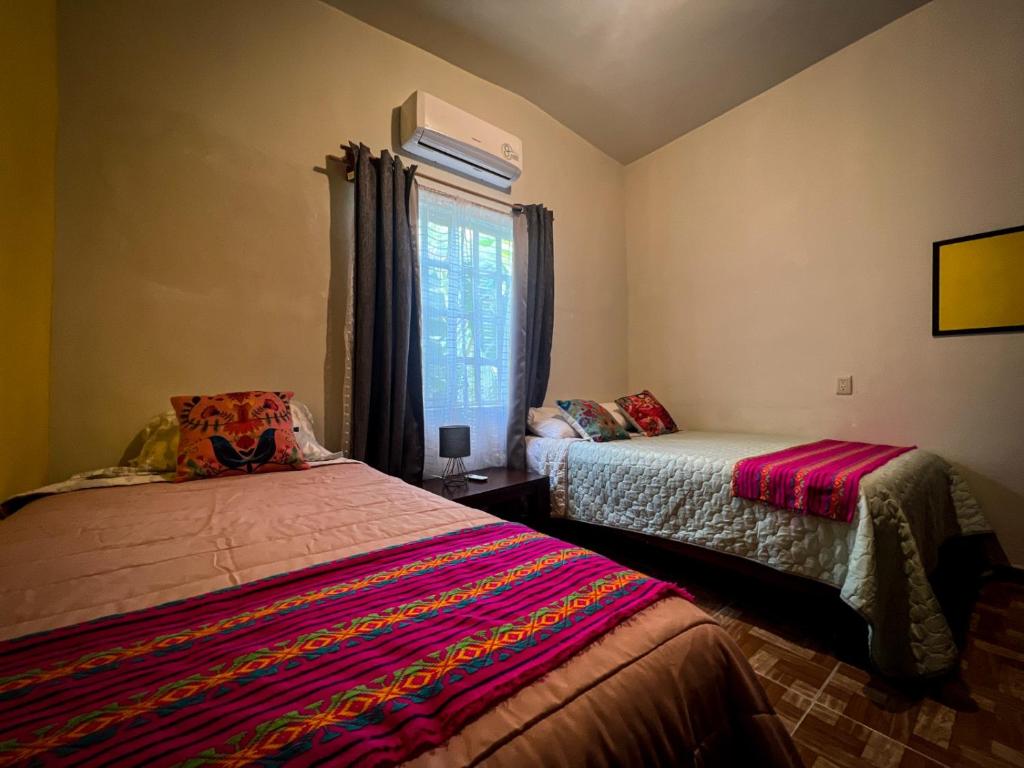 El NaranjoCasa de campo - Ruta Turquesa的一间卧室设有两张床和窗户。