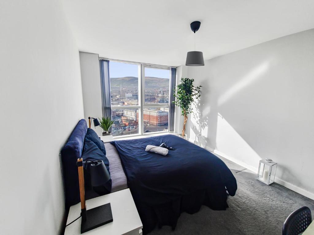 贝尔法斯特Sky High Ensuite Bedroom in Shared Apartment in Belfast City Centre的一间卧室设有一张床和一个大窗户