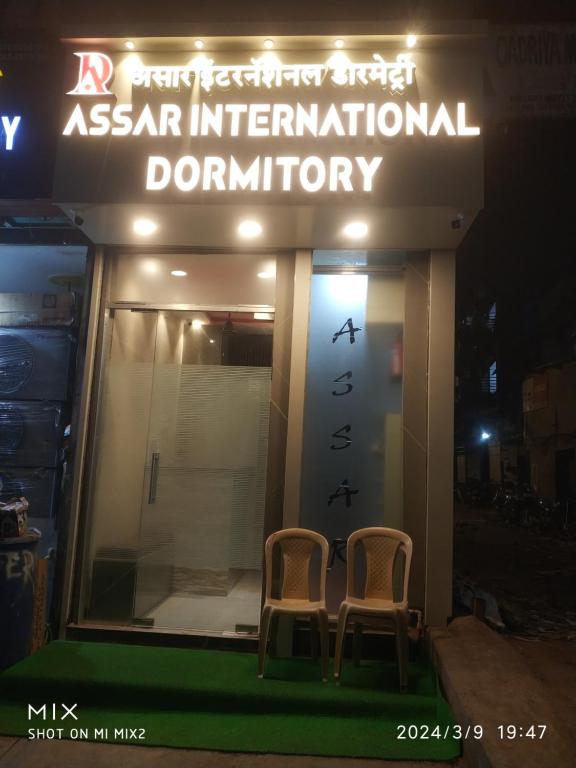 孟买New Assar International dormitory的晚上在餐厅外面坐两把椅子