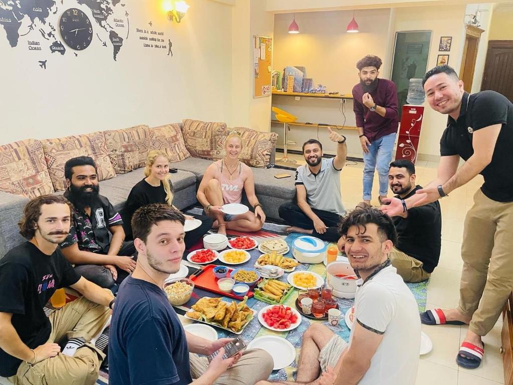 伊斯兰堡Backpackers Hostel Islamabad的一群人坐在桌子旁吃着食物