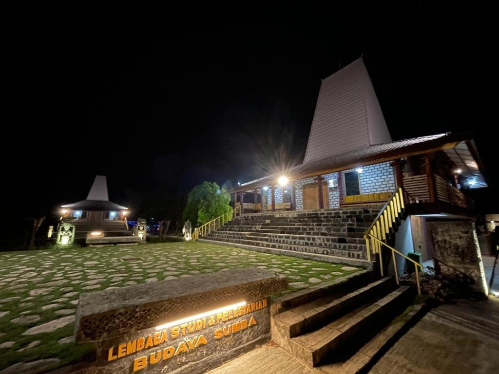 LokokakiRumah Budaya Sumba的一座有楼梯和夜间标志的建筑