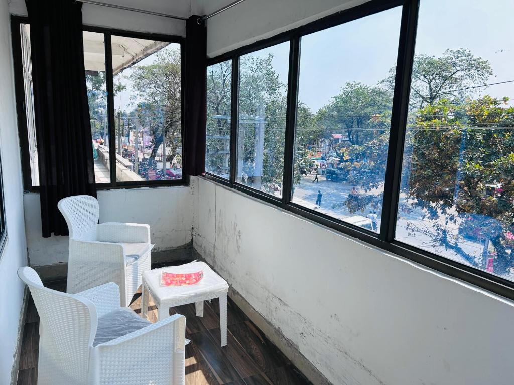 GogāmukhHOTEL CKD的客房设有白色的椅子和享有美景的窗户。