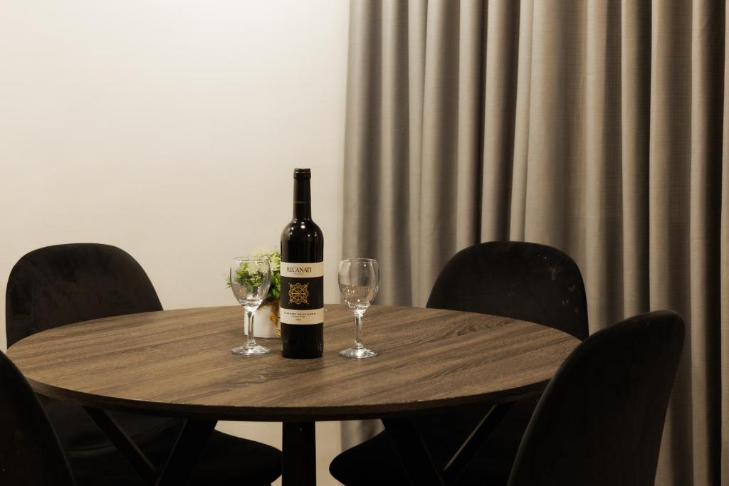 耶路撒冷列夫耶路撒冷酒店的木桌旁的一瓶葡萄酒,带两杯