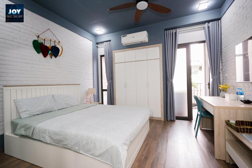 河内JOY APARTMENT TAY HO的一间卧室配有一张床和吊扇