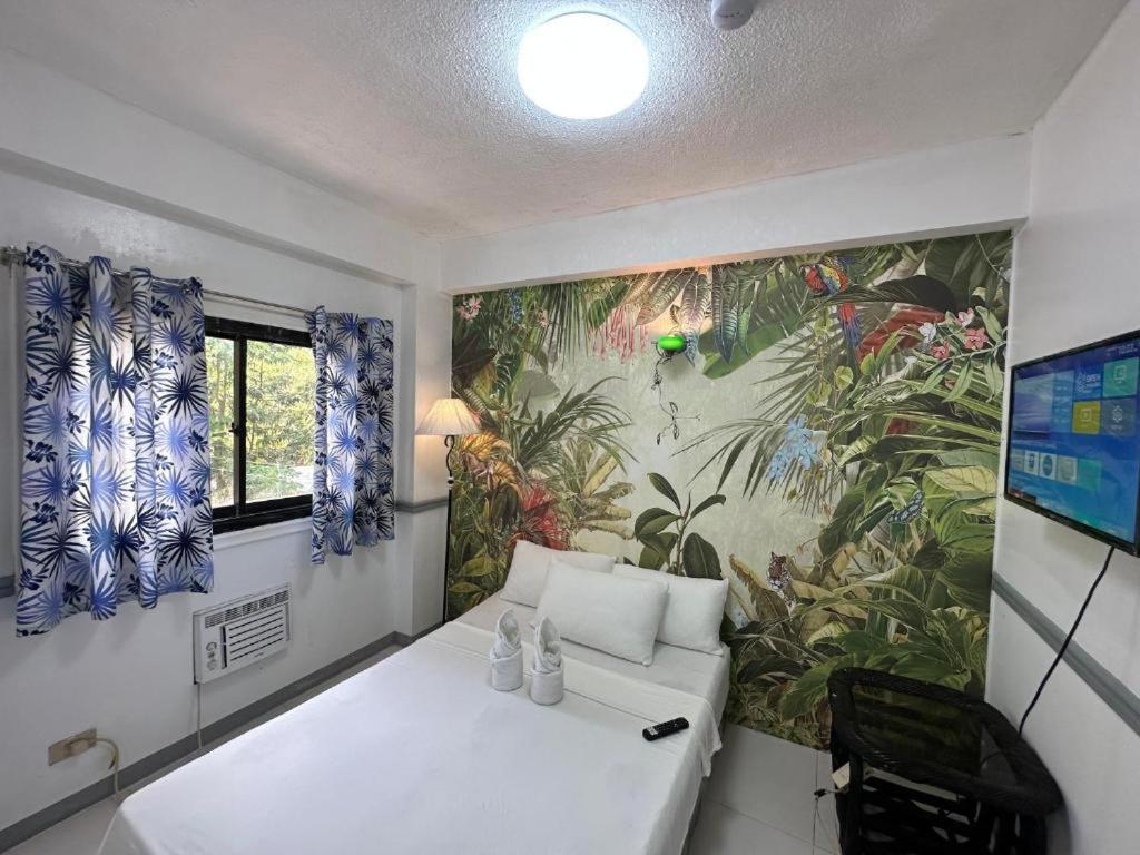 巴旺Generosa Resort的一间设有白色沙发和壁画的房间