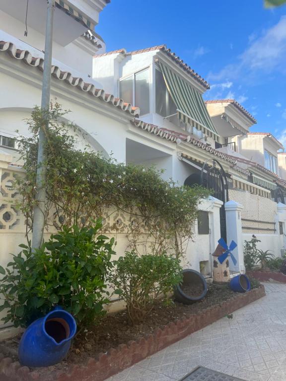 托雷德本纳贾尔邦Casa Pom at the Beach的前面有蓝色的锅的白色建筑