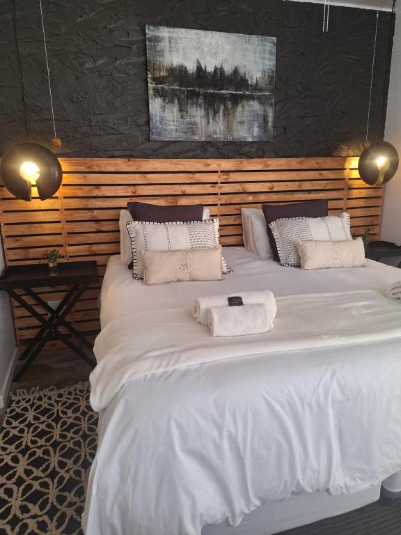 温特和克EXQUISITE PRIVATE LUXURY SUITE WITH KING BED at BOKMAKIERIE VILLAS的一间卧室配有两张带毛巾的床