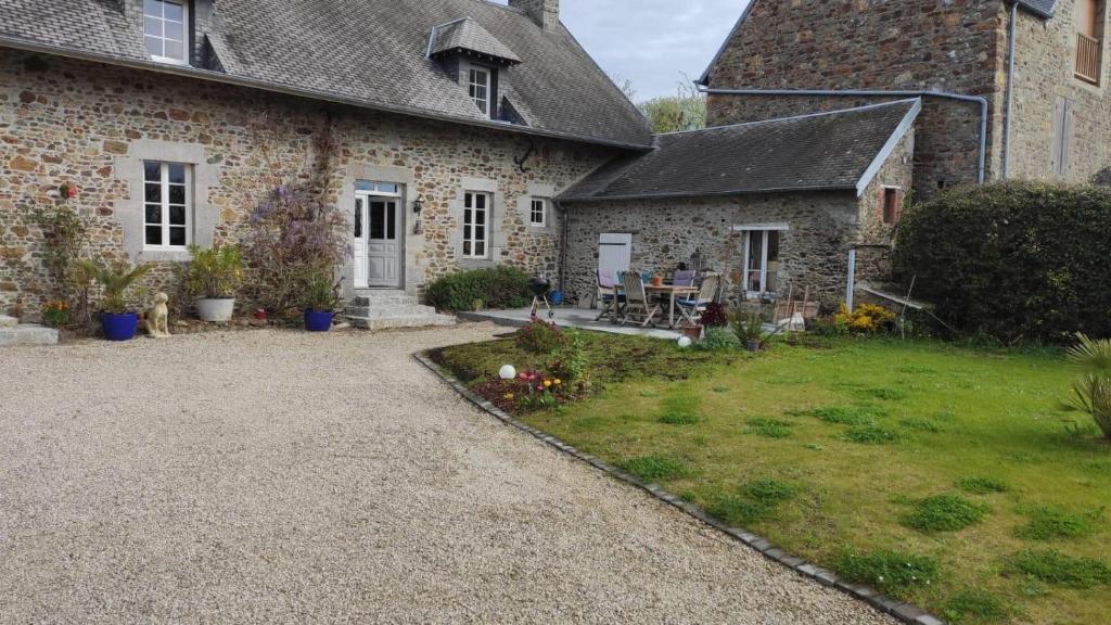 Tourville-sur-SienneChambre d'hôtes的一座石头房子,前面有一座院子