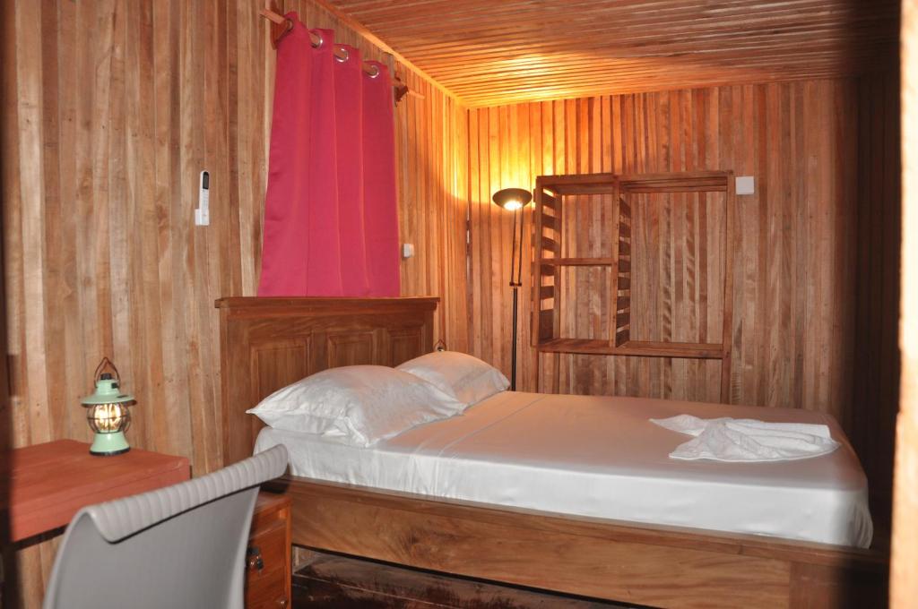 克里比KSW BASE NAUTIQUE Isonalambo的一间卧室配有一张床、一张桌子和红色的窗户