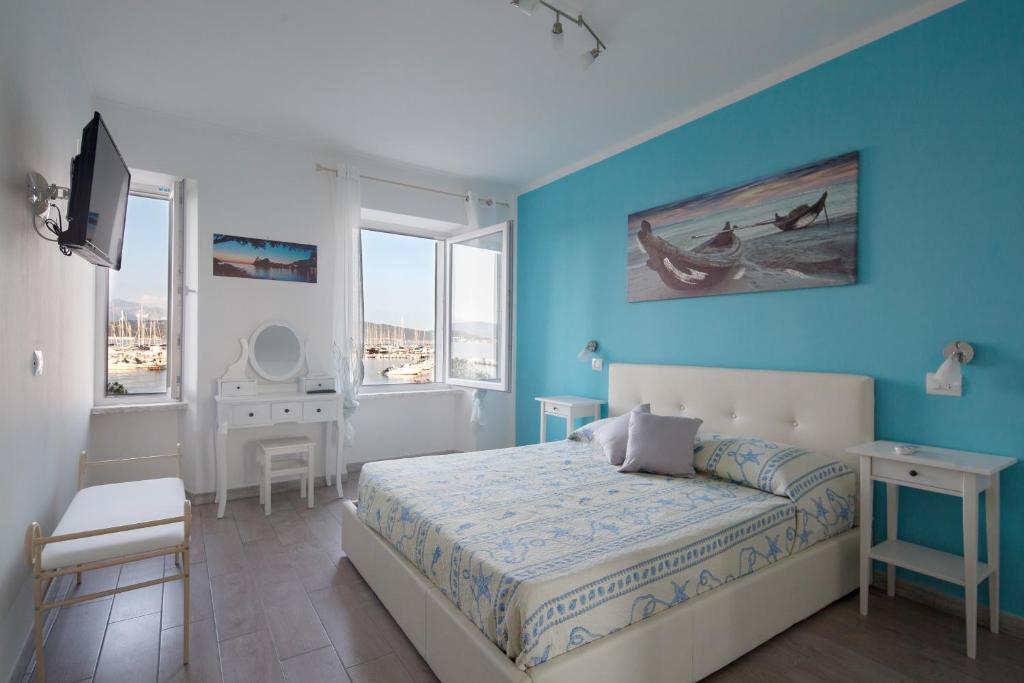 费扎诺Fezzano / Portovenere Stilish double rooms with sea view, balcony or small courtyard的一间卧室设有一张床和蓝色的墙壁