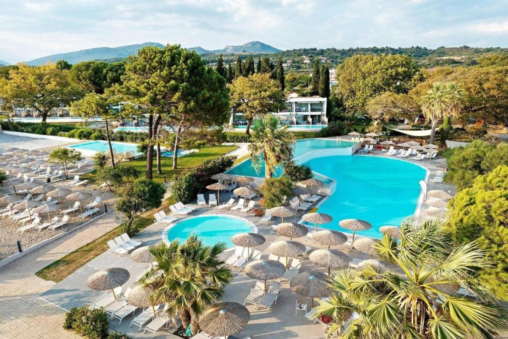 卡斯特罗西基亚Ninos Grand Beach Resort的享有带遮阳伞和椅子的游泳池的顶部景致